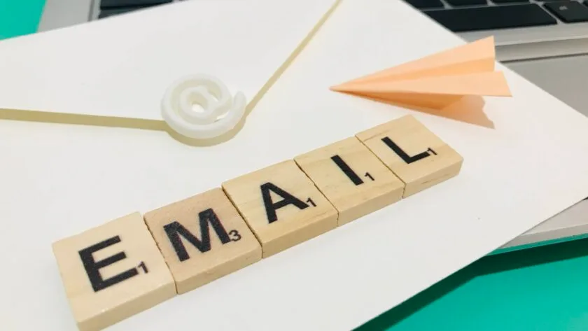 Envelope, paper aeroplane and letters forming the word email on a laptop computer